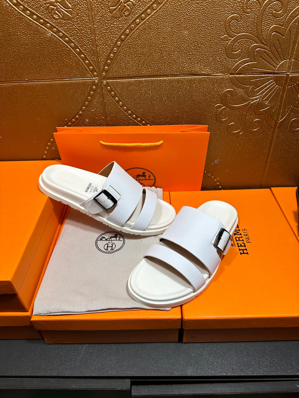 Hermes white leather slide sandals with two straps and silver buckle, pair on display