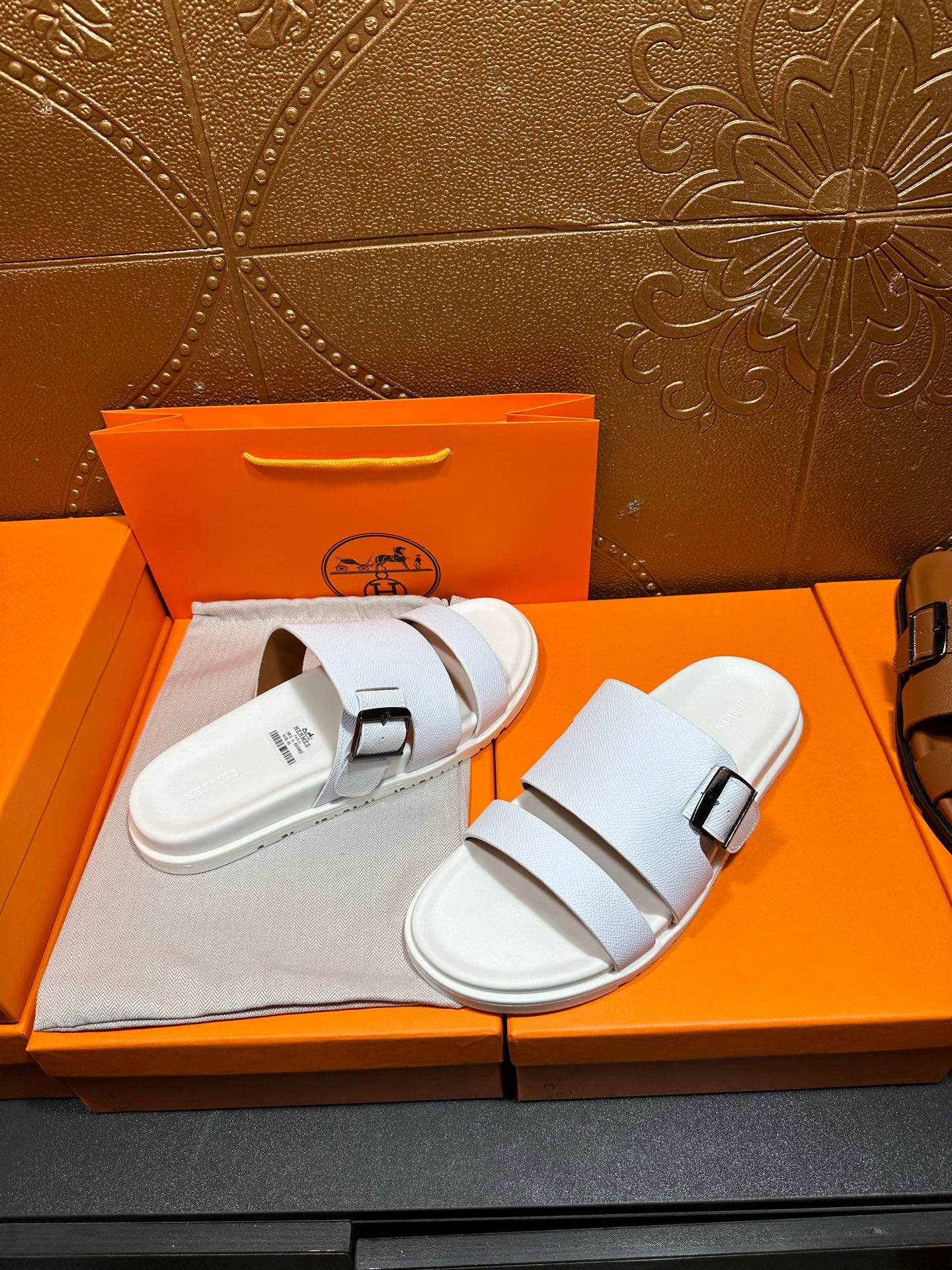 Hermes white leather slide sandals with two straps and silver buckle, pair view
