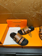 Brown slide sandals with black double strap bands and silver-tone buckles, black footbed.