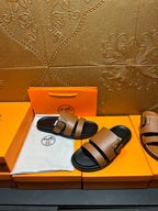 Brown leather slide sandals with black double straps and silver-tone buckles, black sole.