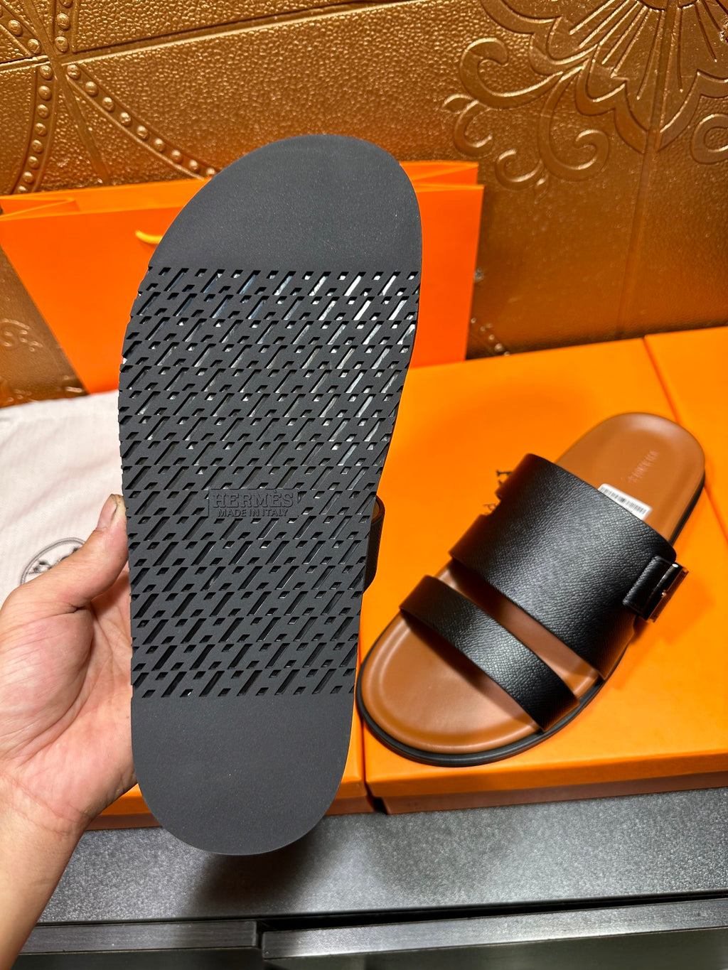 Black slide sandal sole with textured tread, shown next to sandal upper