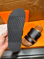 Black slide sandal sole with textured tread, shown next to sandal upper