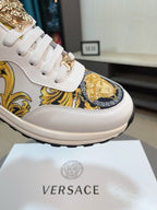 White sneakers with gold emblem detailing on side and lace-up closure