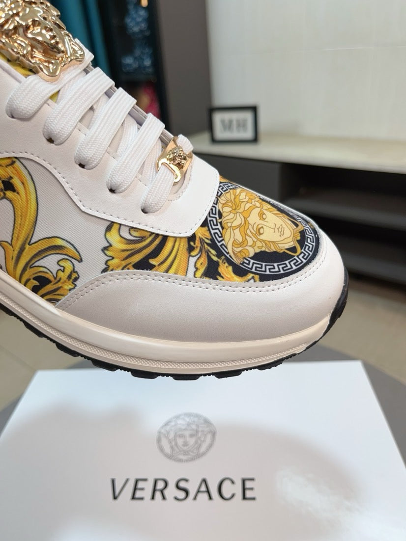 White sneakers with gold emblem detailing on side and lace-up closure