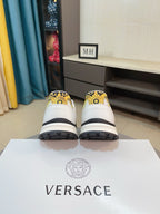 Back view of white sneakers with gold heel accents and chunky dark outsole
