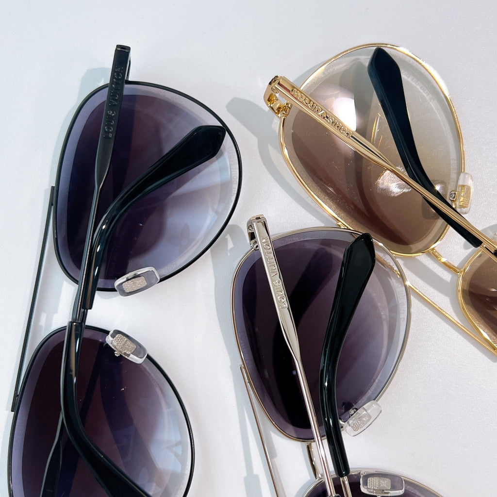 Louis Vuitton sunglasses set with black and gold frames, tinted lenses, and monogram pattern