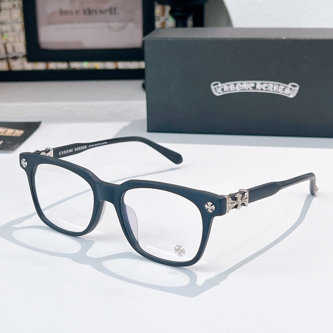 Chrome eyeglasses with dark teal frames, clear lenses, and gold-toned temple details