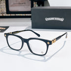 Chrome eyeglasses with dark frames and gold-toned cross embellishment, clear lenses