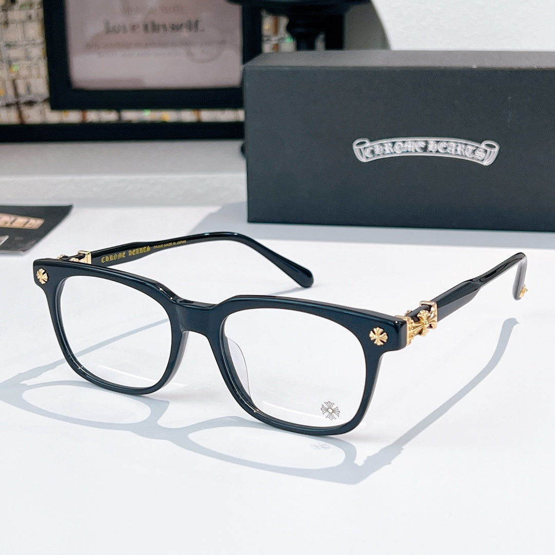 Chrome eyeglasses with dark frames and gold-toned cross embellishment, clear lenses
