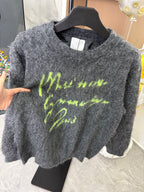 Dark gray fuzzy sweater on hanger with neon green graphic print, long sleeves