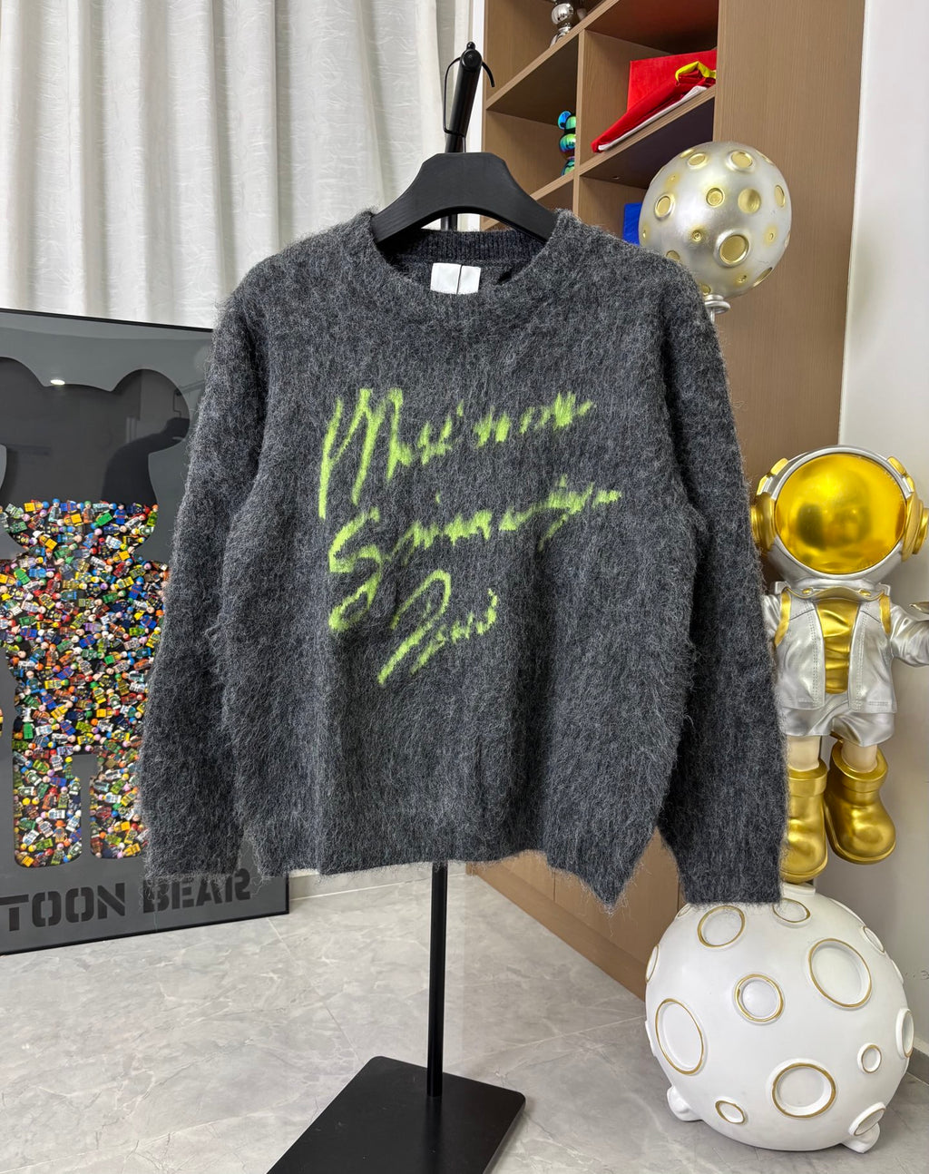 Dark gray fuzzy crewneck sweater with neon green graphic print, long sleeves
