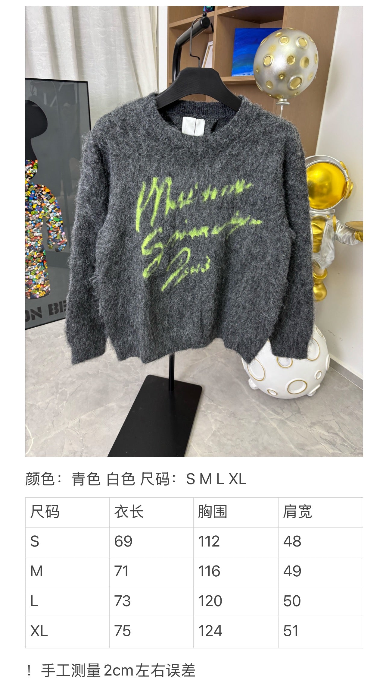 Dark gray fuzzy sweater with neon green graphic print displayed on a stand