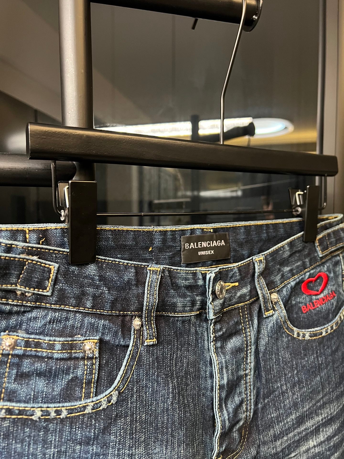 Balenciaga denim shorts waistband detail with belt loops and red heart logo patch