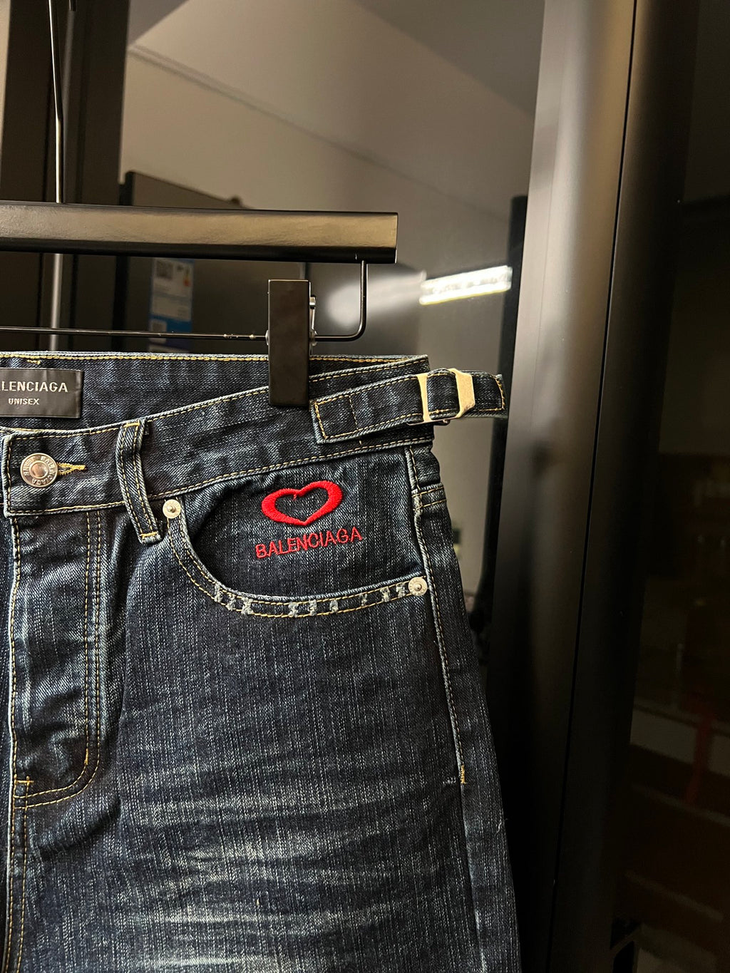 Balenciaga denim shorts waist detail with red heart logo patch and gold-trim stitching