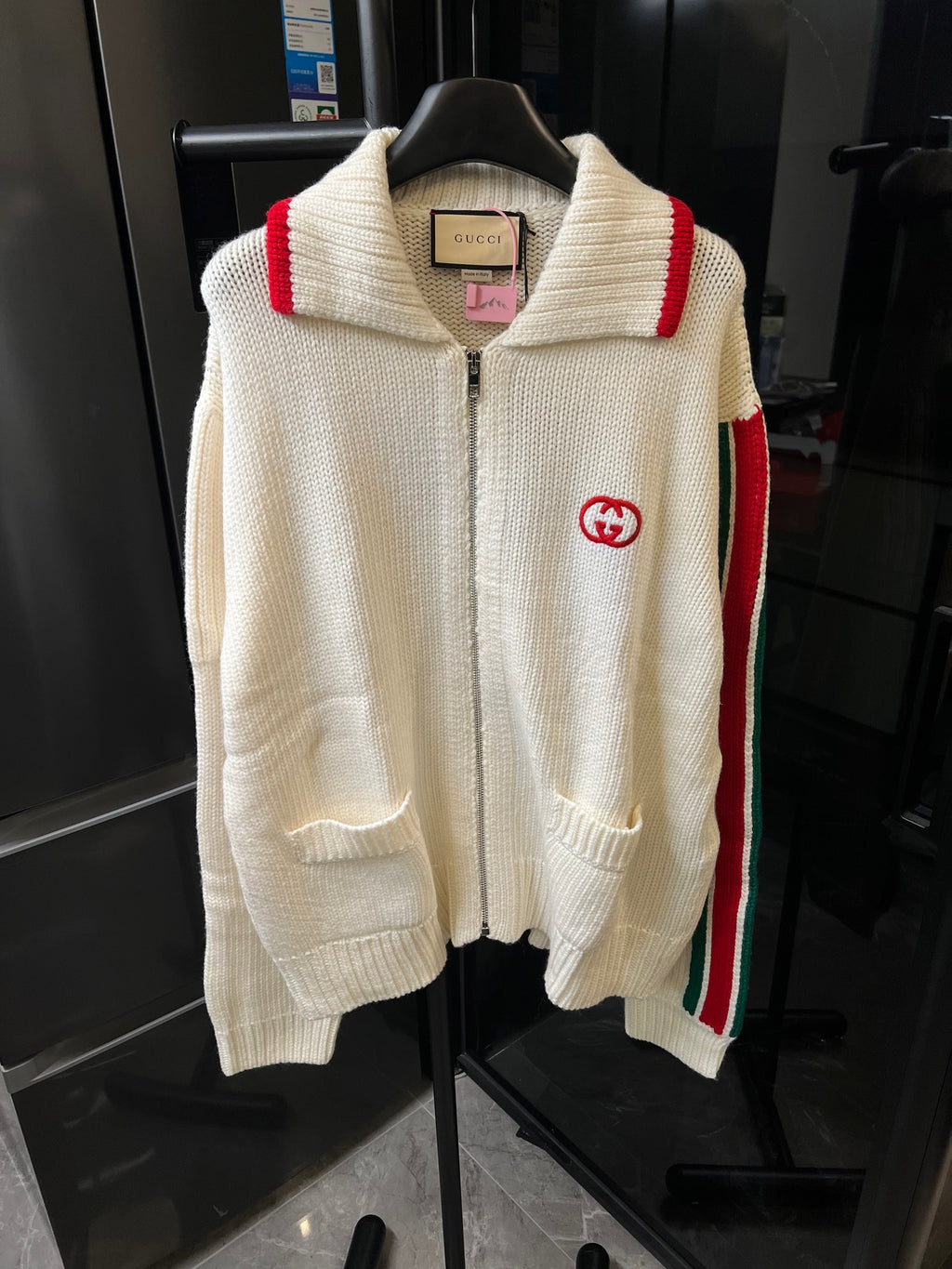 Gucci cream knit zip-up sweater front view, red shoulder stripe and GG logo patch