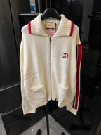 Gucci cream knit zip-up sweater front view, red shoulder stripe and GG logo patch