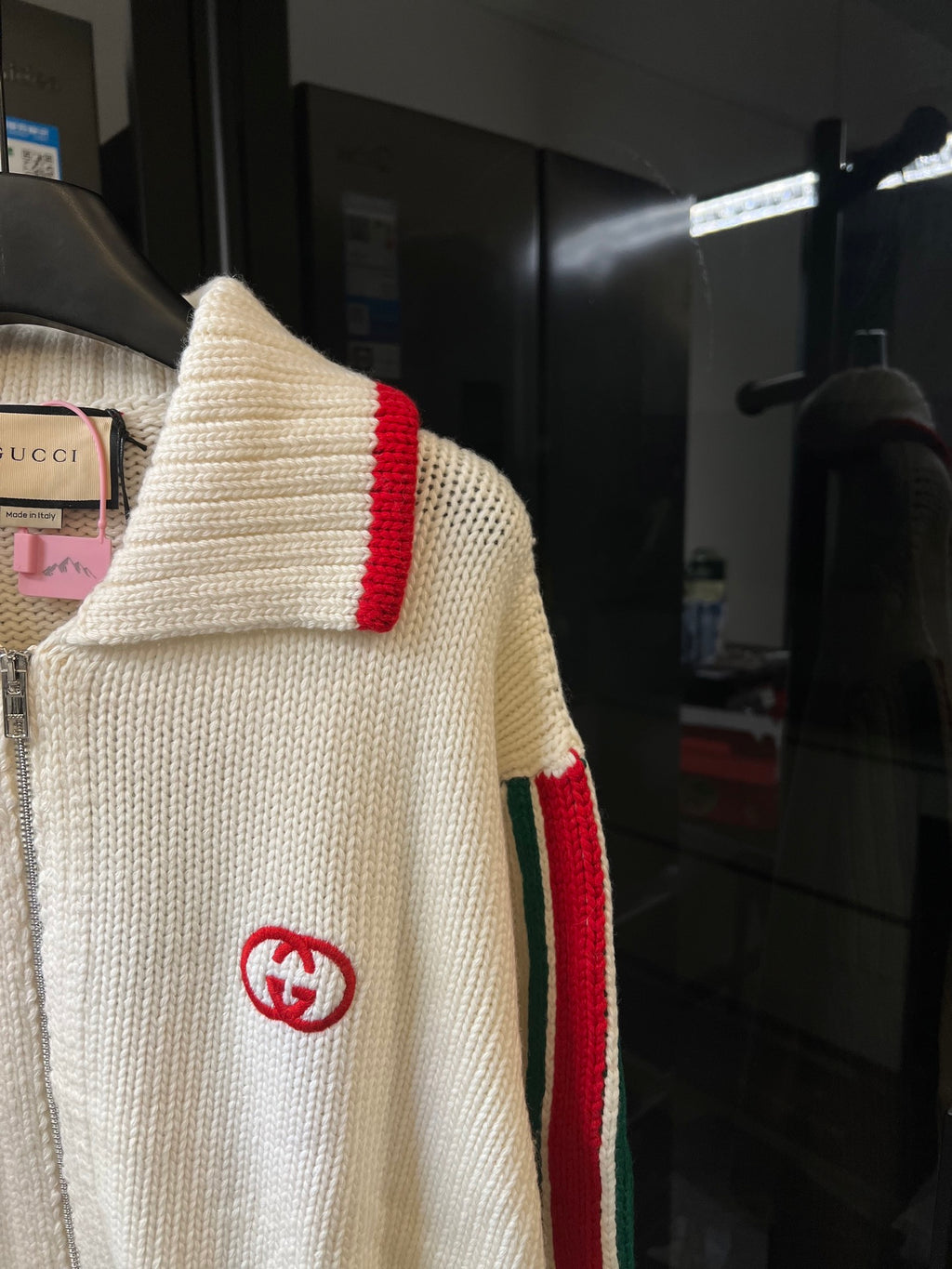 Gucci cream knit sweater showing red shoulder stripe and GG logo on sleeve