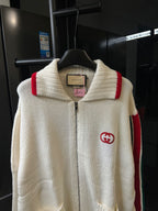 Gucci cream knit zip-up sweater close-up with ribbed collar and red stripe detail