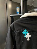 Black denim jacket back with blue and white cross patch, sherpa collar, buttoned