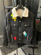 Black denim jacket with sherpa collar, button front, patch pockets, cross appliqués