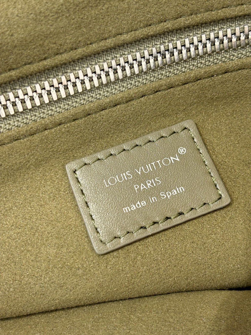 Olive green leather bag with Louis Vuitton Paris label and stitched patch