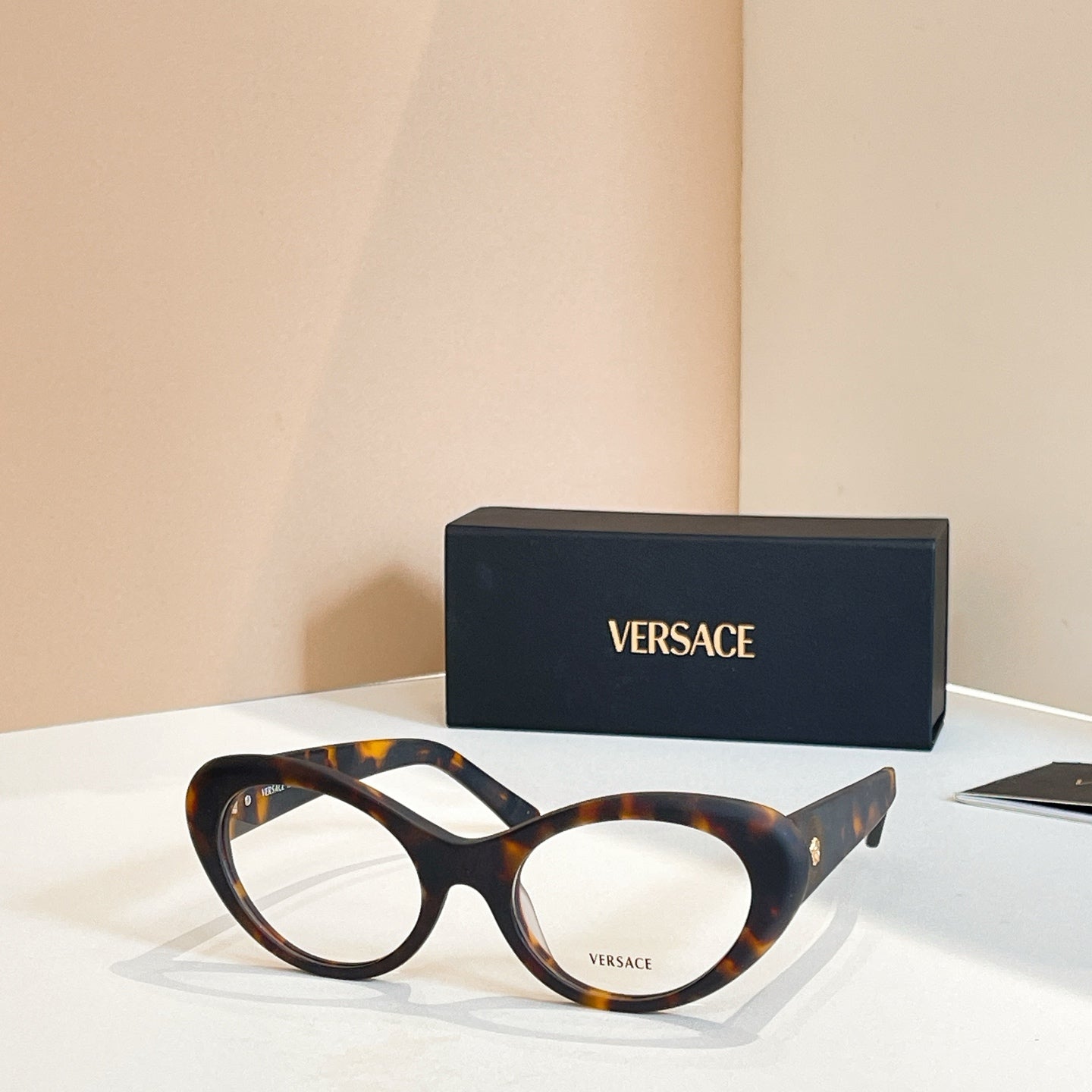 Round eyeglasses with tortoiseshell frames and clear lenses, side stripe detail