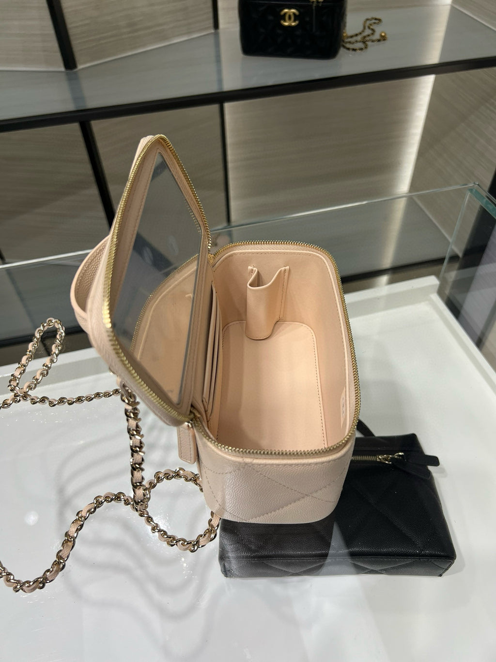 Chanel mini bag, light beige, open top with chain strap and zipper closure.