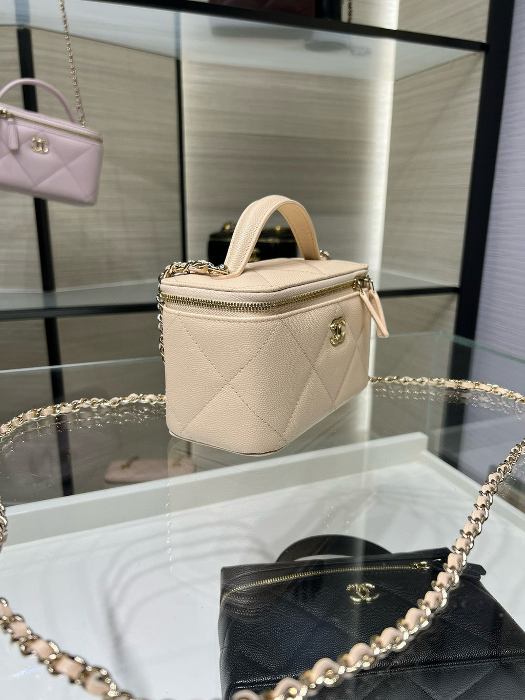 Chanel quilted handbag in light beige with zip closure and top handle.
