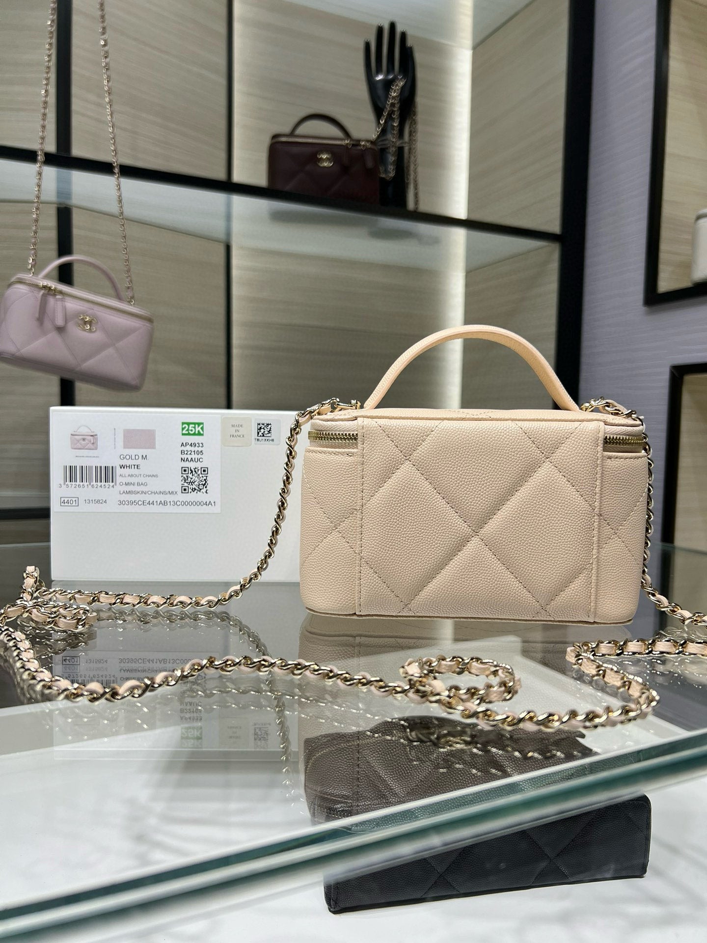 Chanel quilted handbag in light beige with zip top and chain shoulder strap.