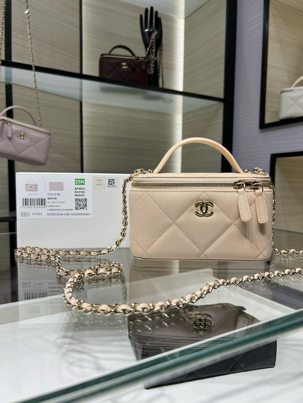 Chanel quilted handbag, light beige with top handle and chain strap.