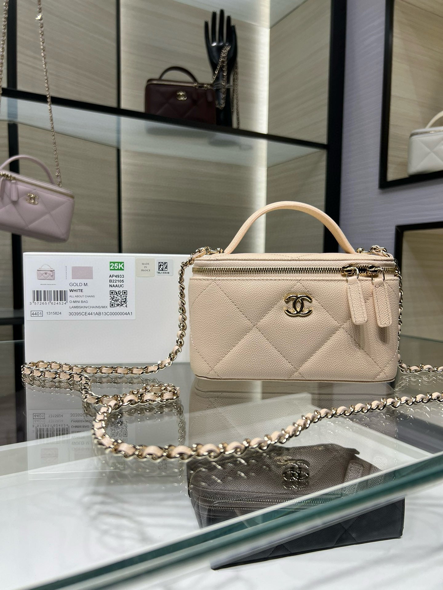 Chanel quilted handbag, light beige with top handle and chain strap.