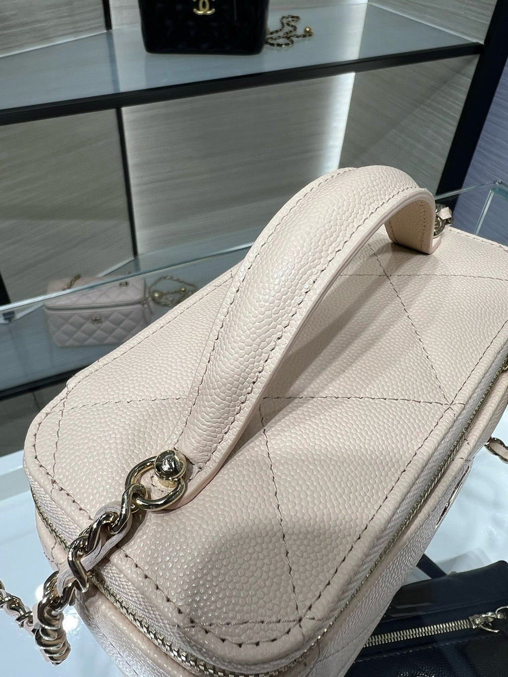 Chanel quilted mini bag, light beige, textured leather with metal chain attachment.
