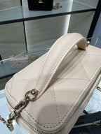 Chanel quilted mini bag, light beige, textured leather with metal chain attachment.