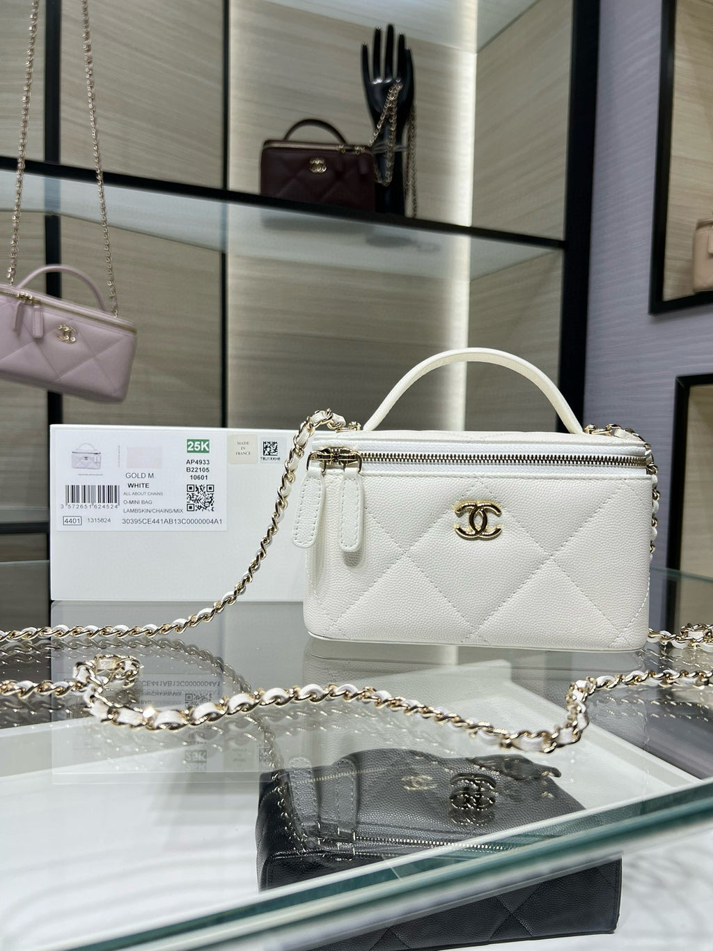 White quilted handbag with top handle, gold chain strap, and CC logo front.