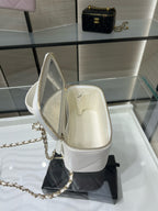 Open white mini handbag with gold chain strap and leather lining, CC-style detail.