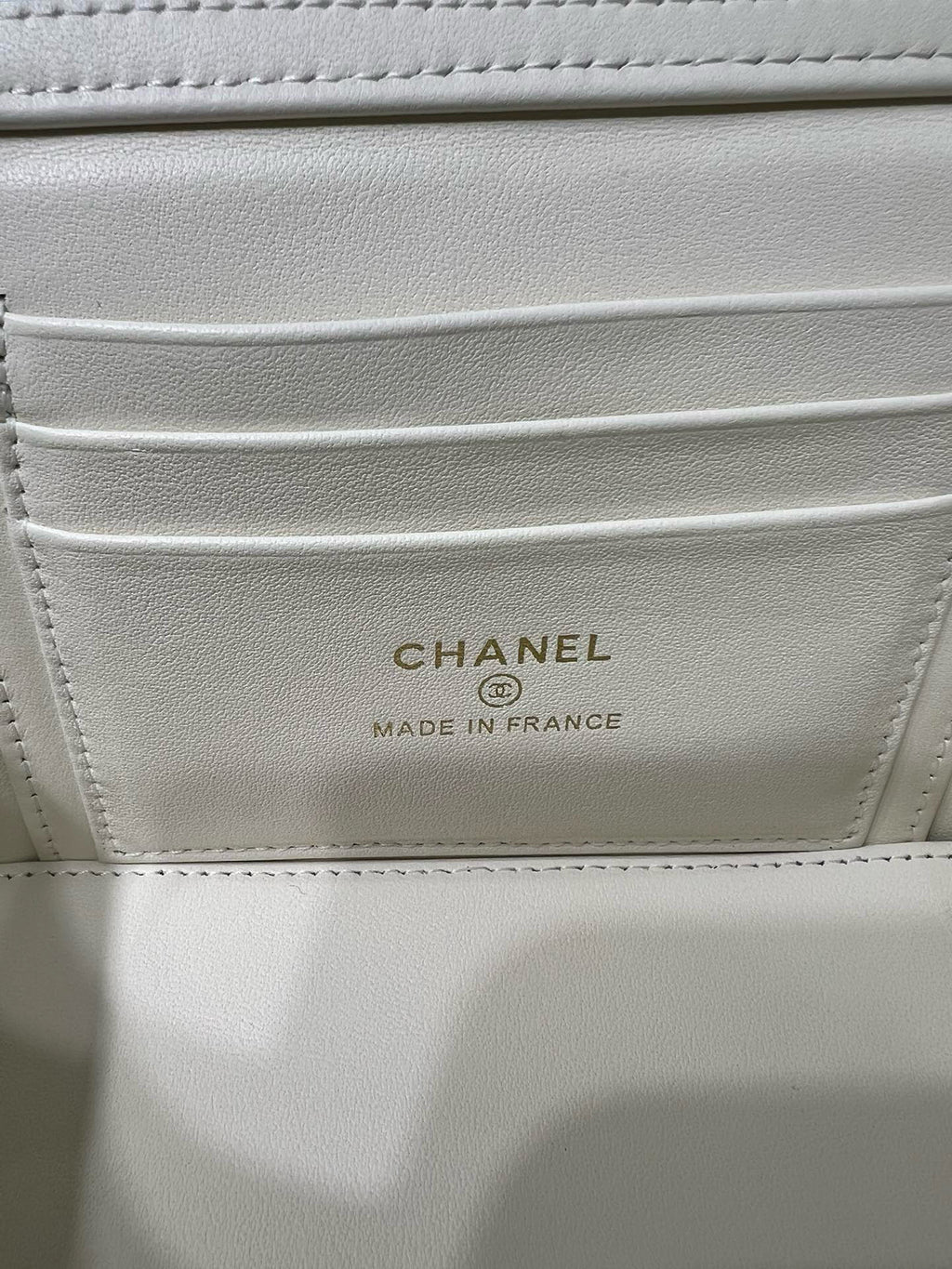 White handbag interior label reading CHANEL and MADE IN FRANCE.