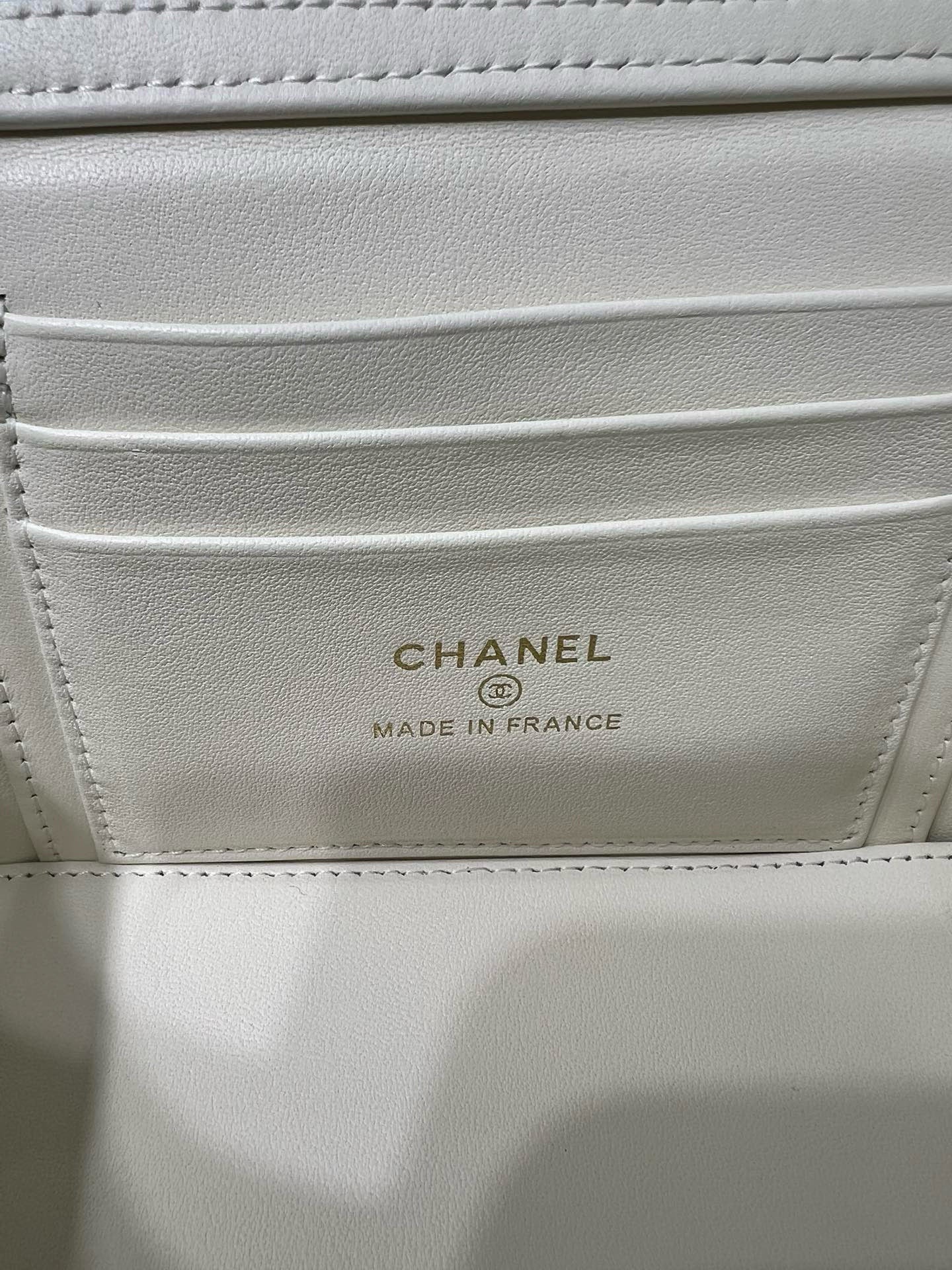 White handbag interior label reading CHANEL and MADE IN FRANCE.