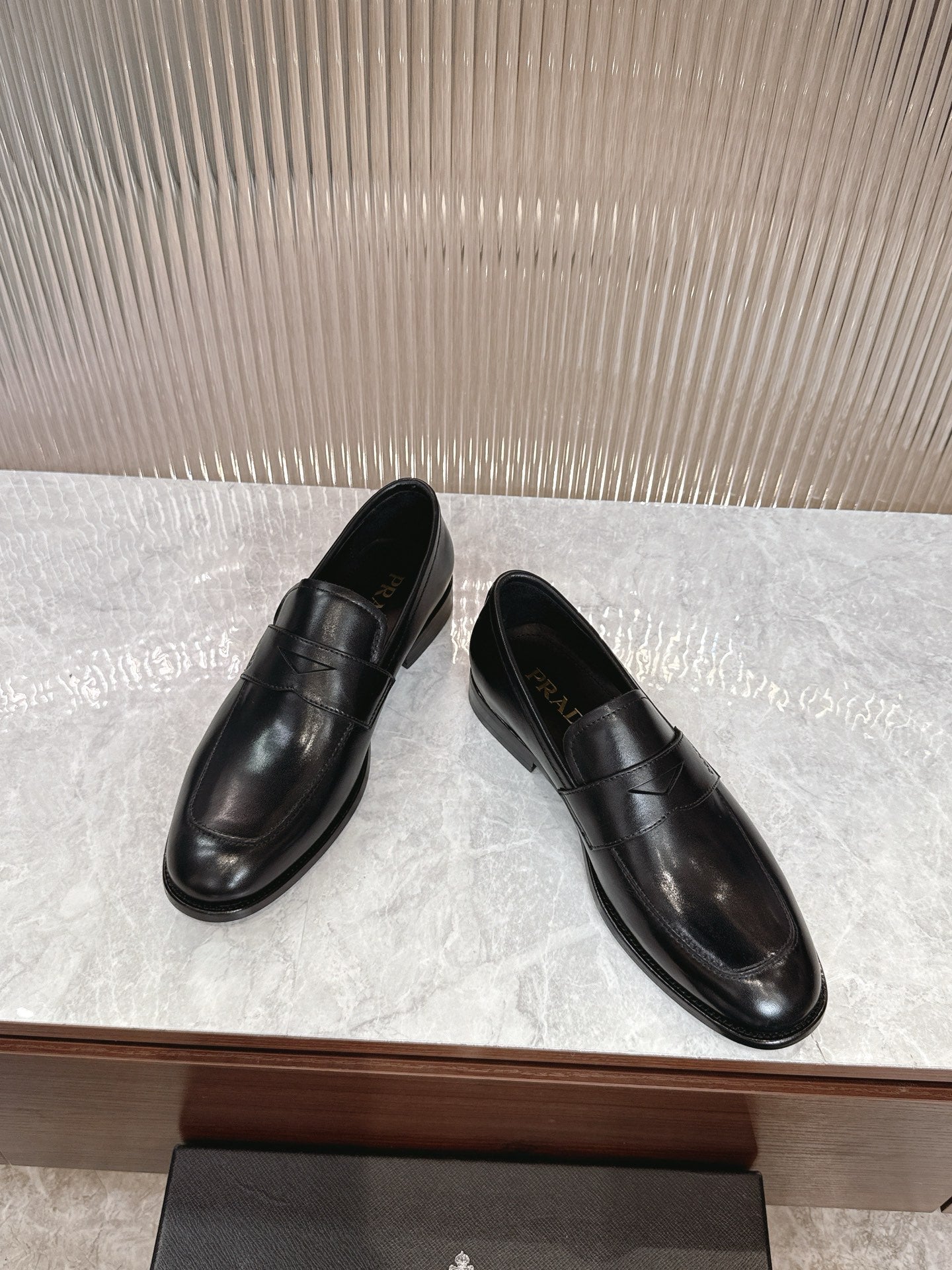 Black leather slip-on loafers, side view, smooth upper and low heel
