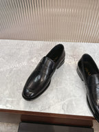 Black leather slip-on loafers, front angle with stitched vamp and low profile heel