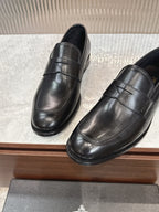 Black leather slip-on loafers, close side view with stitched seam across vamp