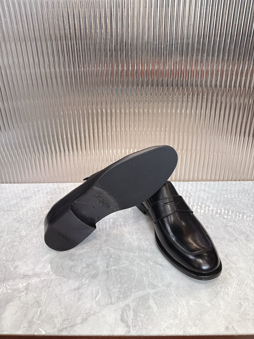 Black leather loafer with flat sole, side angle showing heel and toe