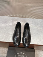 Black leather slip-on loafers with stitched panel and almond toe