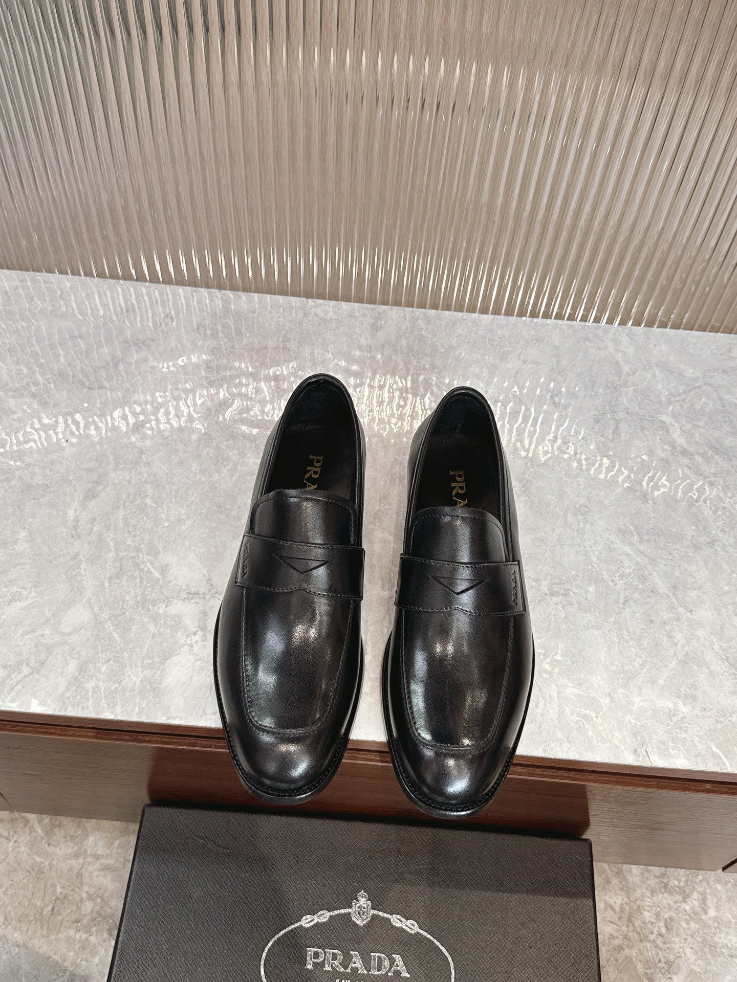 Black leather slip-on loafers with stitched panel and almond toe