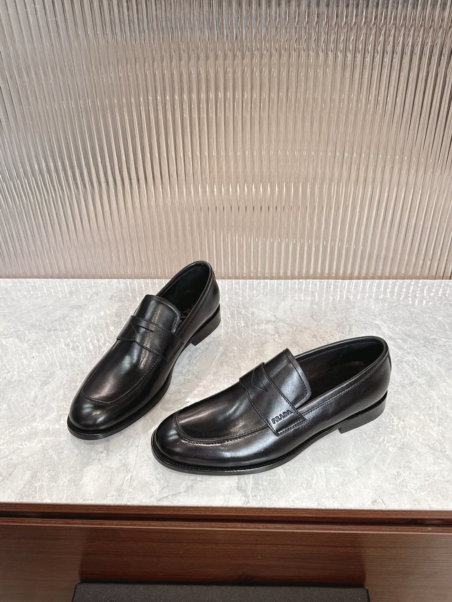 Black leather loafers, angled view, smooth upper and low profile heel