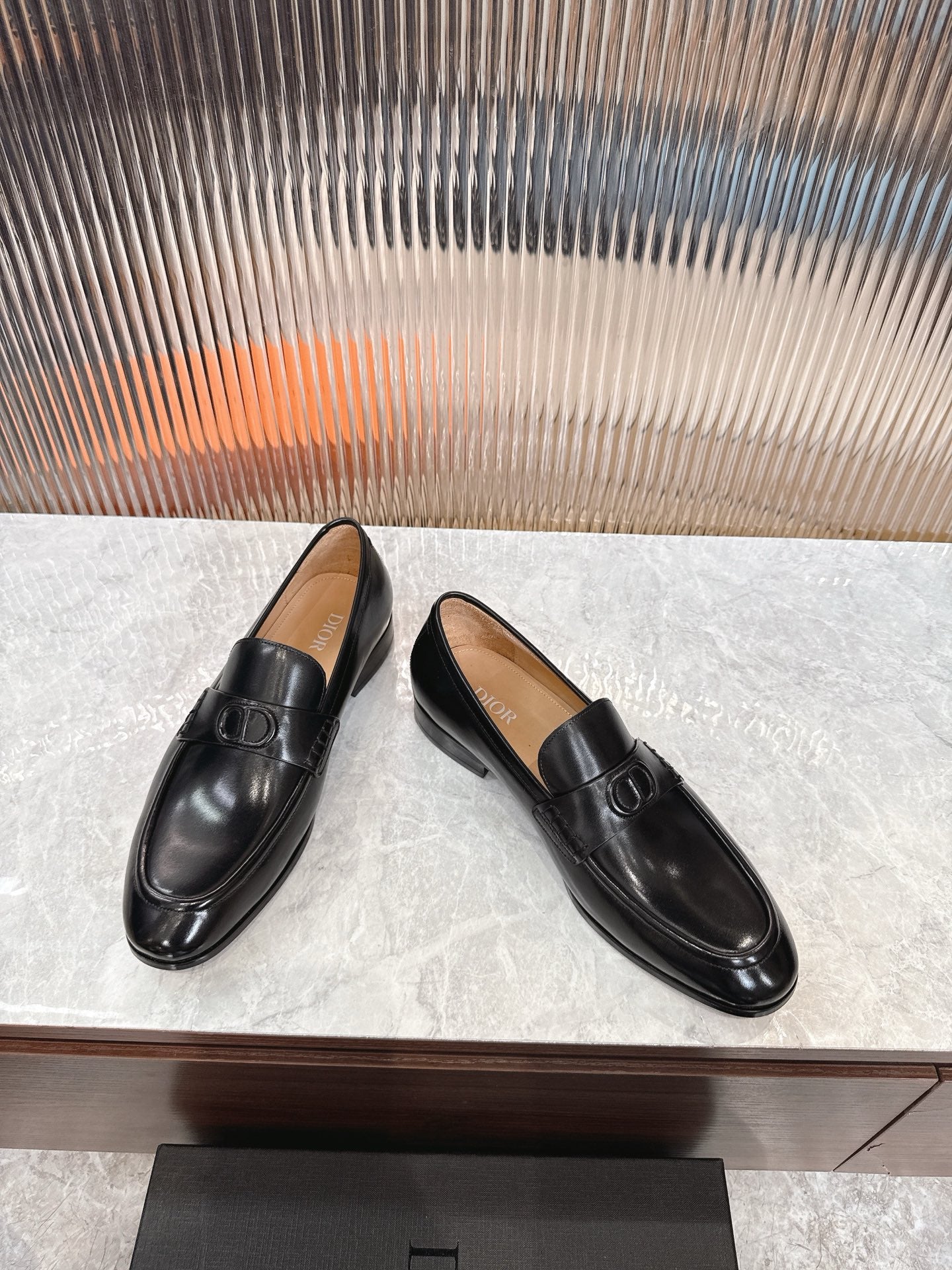 Black leather unisex loafers, angled view with square buckle on vamp.