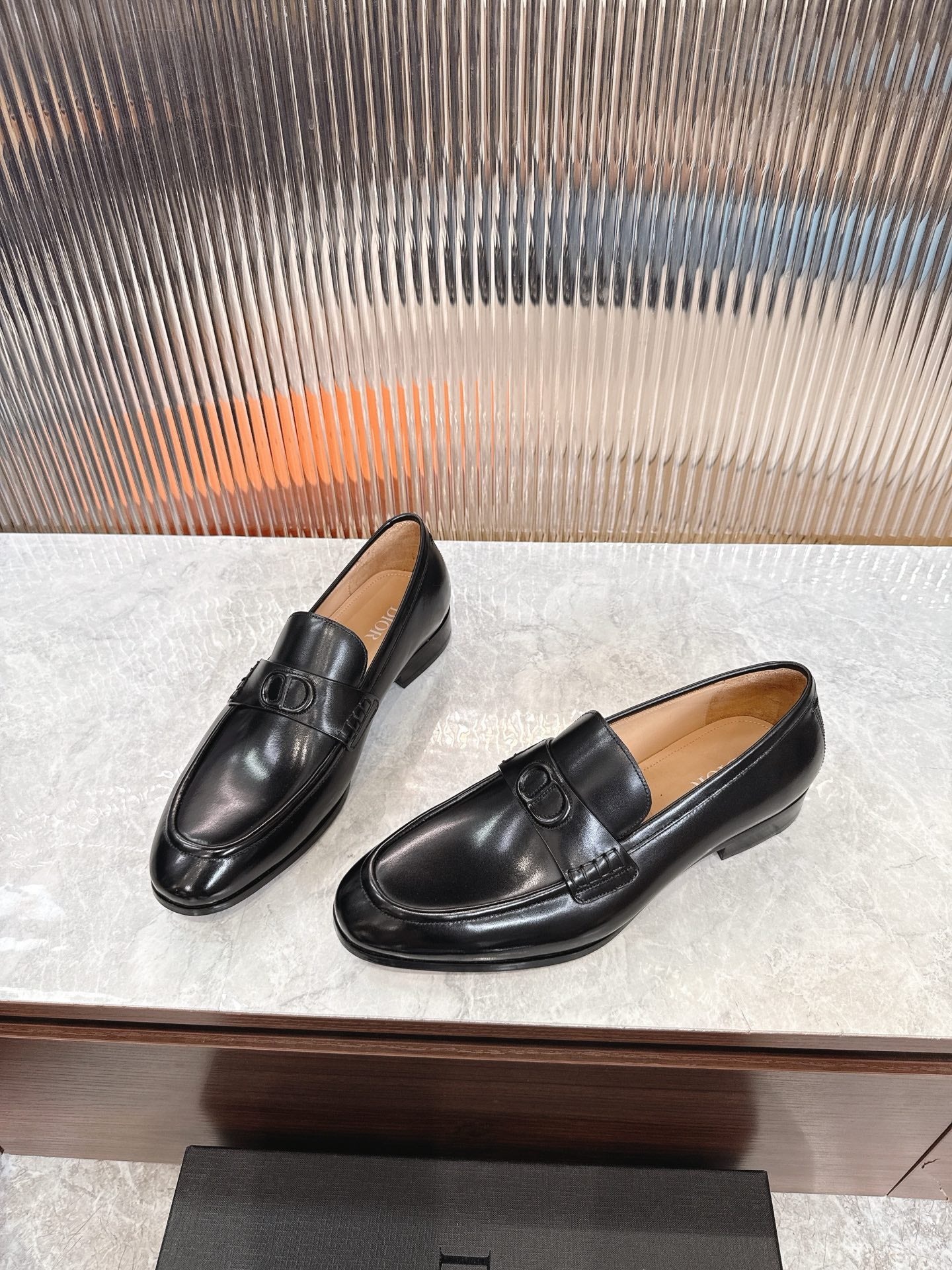 Black leather unisex loafers, side profile with strap buckle detail.