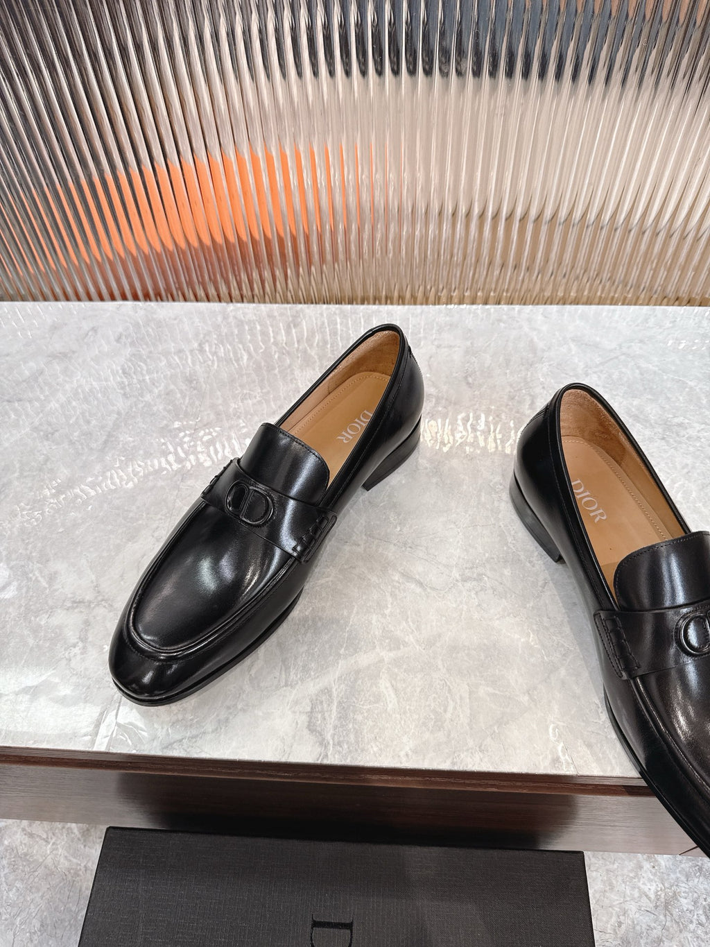 Black leather unisex loafers, angled view of saddle strap and buckle.