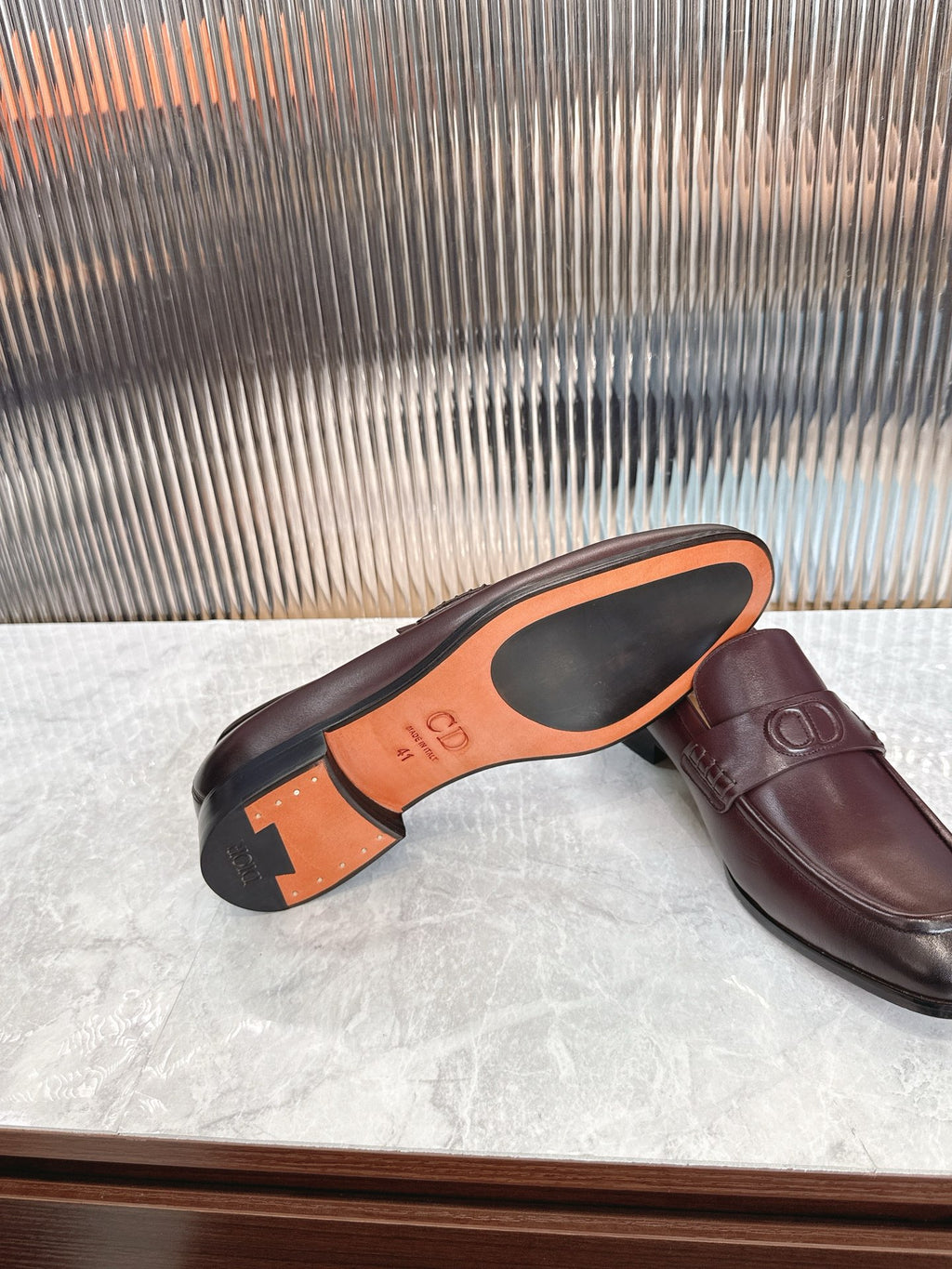 Burgundy leather loafer underside and side view, orange sole markings
