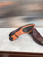Burgundy leather loafer underside and side view, orange sole markings