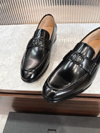 Dior unisex black leather loafers, front view with logo buckle detail